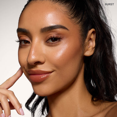 {Burst} Model wearing Morphe Complexion Boost Peptide Bronzing Serum in Burst, showing a dewy, bronzed complexion