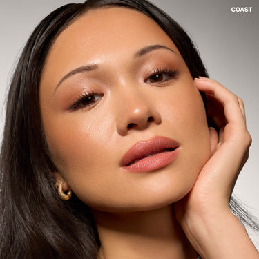 {Coast} Model wearing Morphe Complexion Boost Peptide Bronzing Serum in Coast, showing a dewy, bronzed complexion