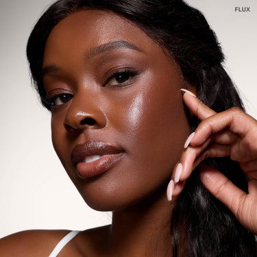 {Flux} Model wearing Morphe Complexion Boost Peptide Bronzing Serum in Flux, showing a dewy, bronzed complexion