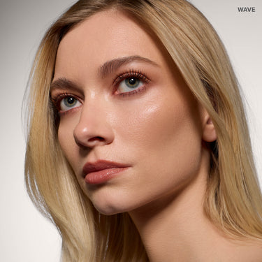 {Wave} Model wearing Morphe Complexion Boost Peptide Bronzing Serum in Wave, showing a dewy, bronzed complexion